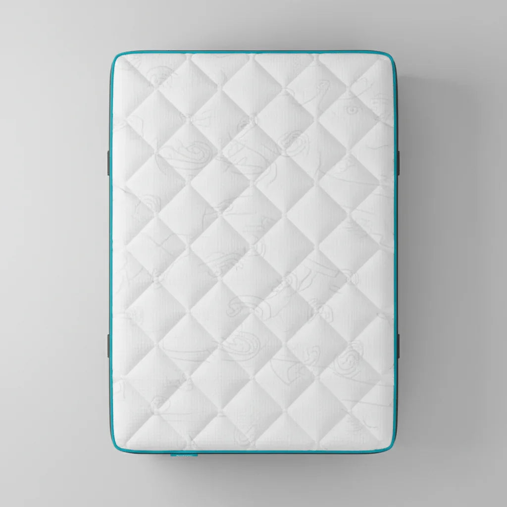 Top view of a white quilted mattress with blue piping on a gray background